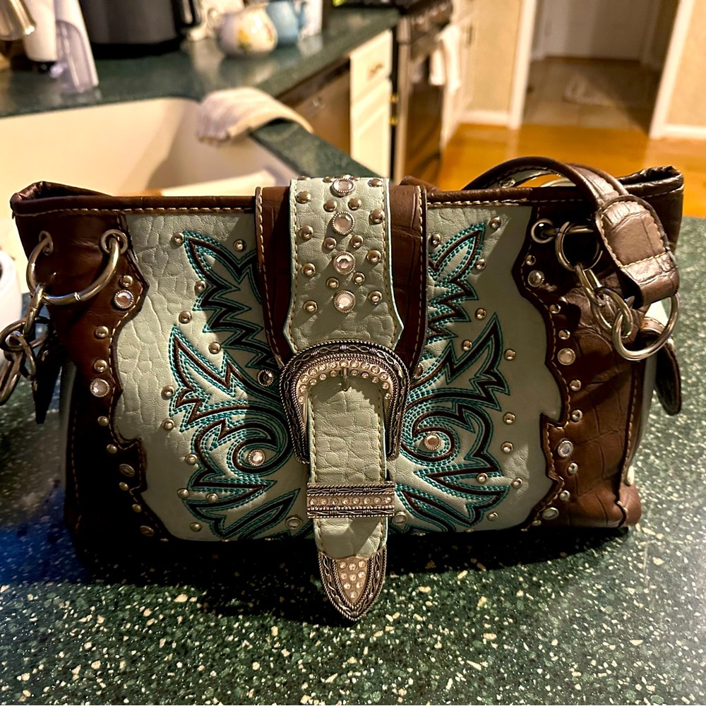Leather purse and silver accents, western style.